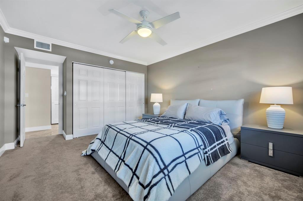 615 North Riverside Drive, Unit 702 Pompano Beach, FL 33062 - Photo 29 of 38 a bedroom with a bed and a lamp on dresser