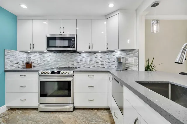a kitchen with white cabinets stainless steel appliances and sink