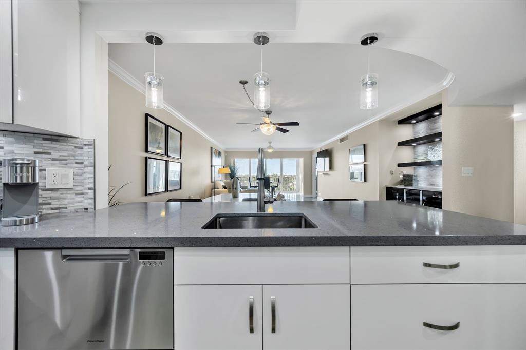 615 North Riverside Drive, Unit 702 Pompano Beach, FL 33062 - Photo 7 of 38 a kitchen with kitchen island a counter space a sink and appliances