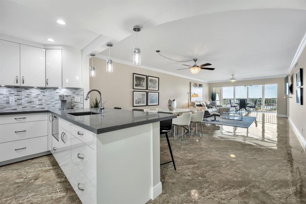 615 North Riverside Drive, Unit 702 Pompano Beach, FL 33062 - Photo 8 of 38 a kitchen with lots of counter space and windows