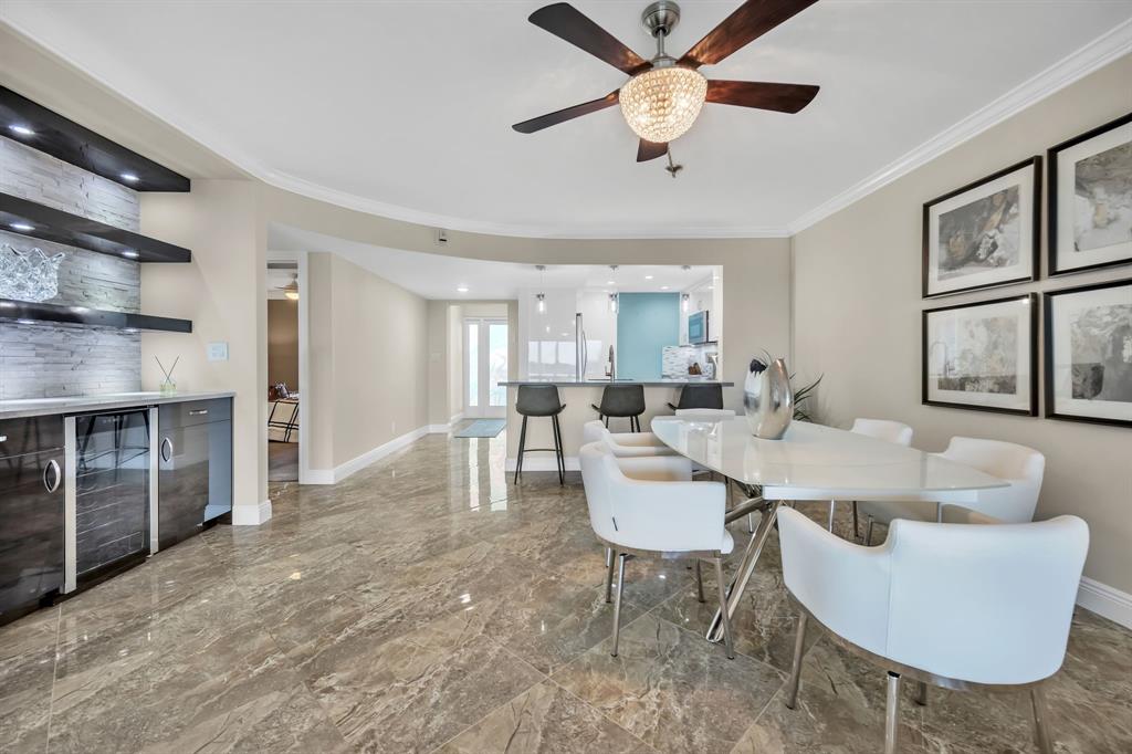 615 North Riverside Drive, Unit 702 Pompano Beach, FL 33062 - Photo 9 of 38 a living room with furniture a flat screen tv and a large window