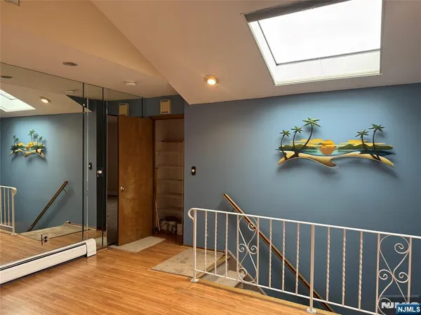 a view of a hallway with wooden floor and a window