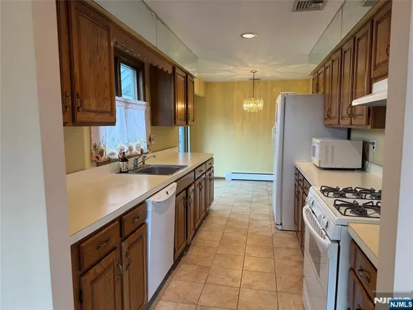 a kitchen with granite countertop wooden cabinets and white appliances