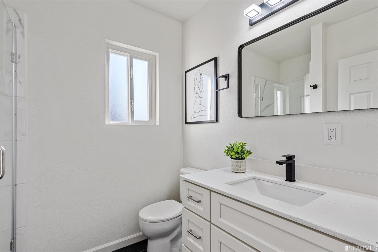 5955 Hayes Street Oakland, CA 94621 - Photo 12 of 20 a bathroom with a sink a toilet and mirror