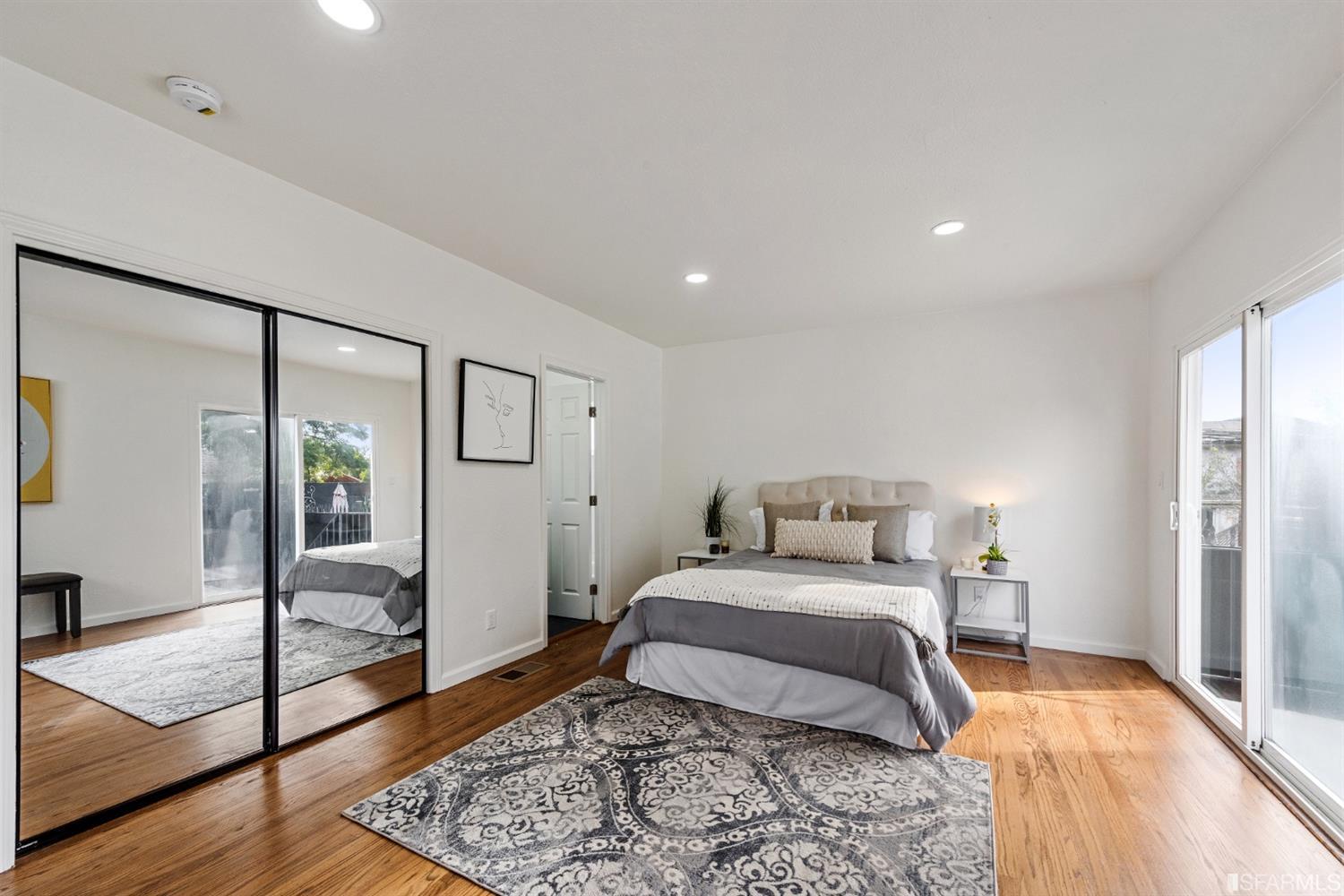 5955 Hayes Street Oakland, CA 94621 - Photo 14 of 20 a bedroom with a bed and a dresser with wooden floor