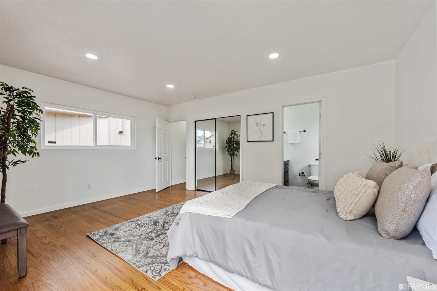 5955 Hayes Street Oakland, CA 94621 - Photo 15 of 20 a bedroom with a large bed and wooden floor