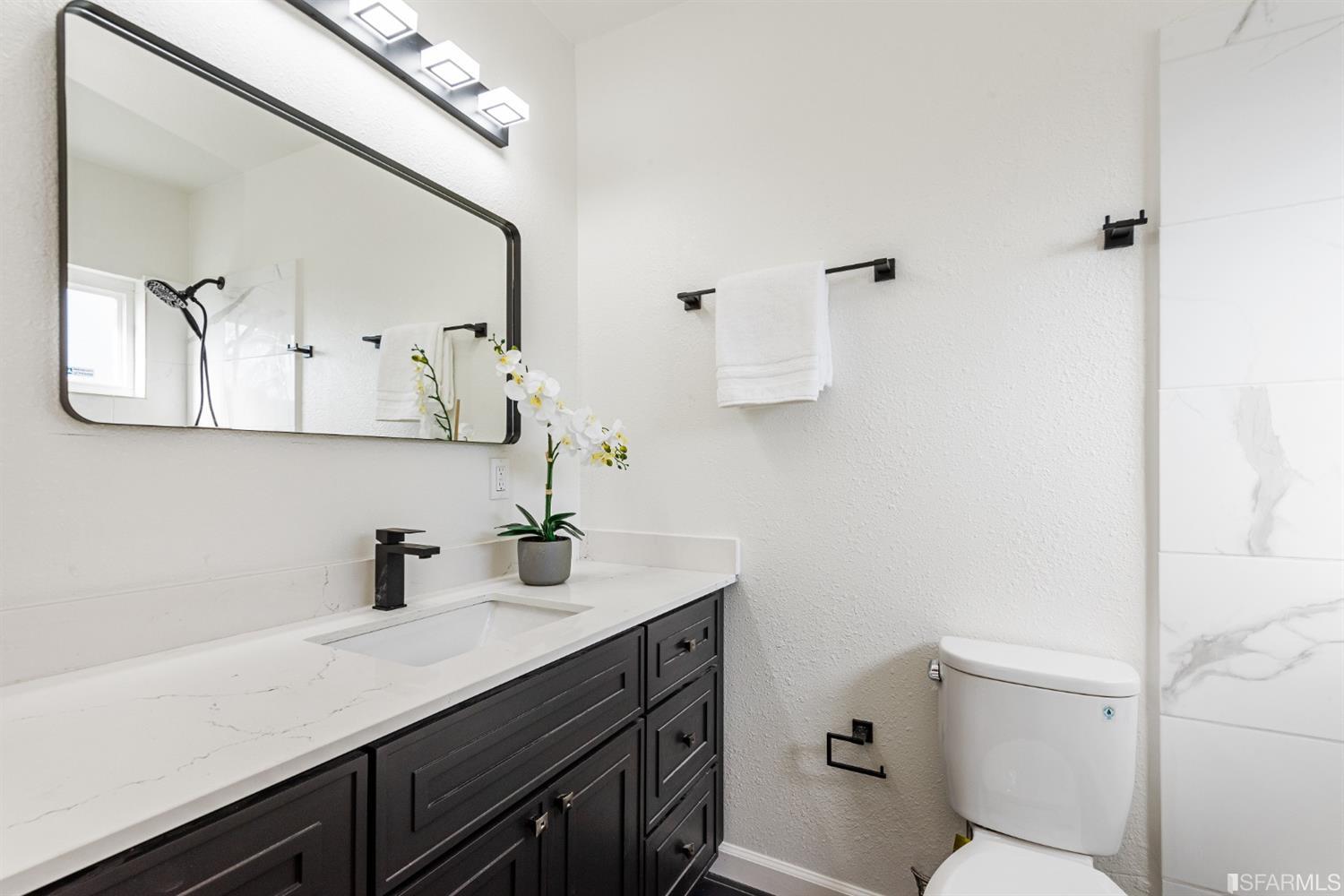5955 Hayes Street Oakland, CA 94621 - Photo 16 of 20 a bathroom with a sink a toilet and mirror