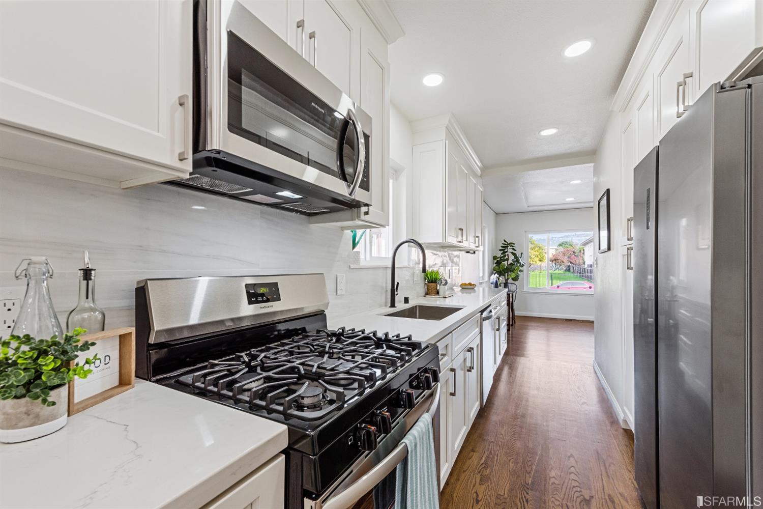 5955 Hayes Street Oakland, CA 94621 - Photo 7 of 20 a kitchen with stainless steel appliances kitchen island granite countertop a stove a refrigerator and a microwave