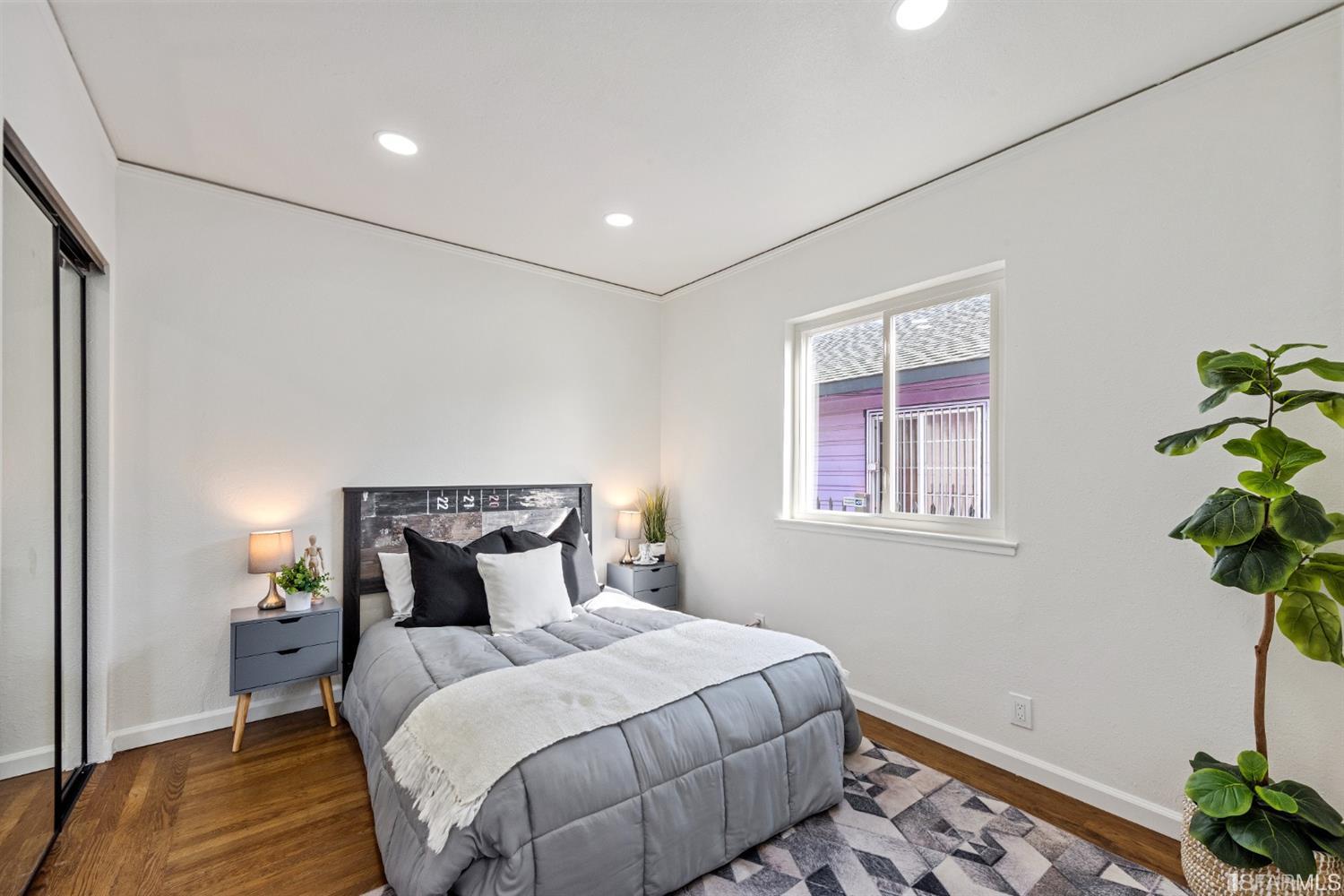 5955 Hayes Street Oakland, CA 94621 - Photo 8 of 20 a bedroom with a bed and a potted plant