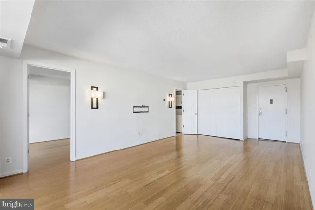 a view of an empty room with wooden floor