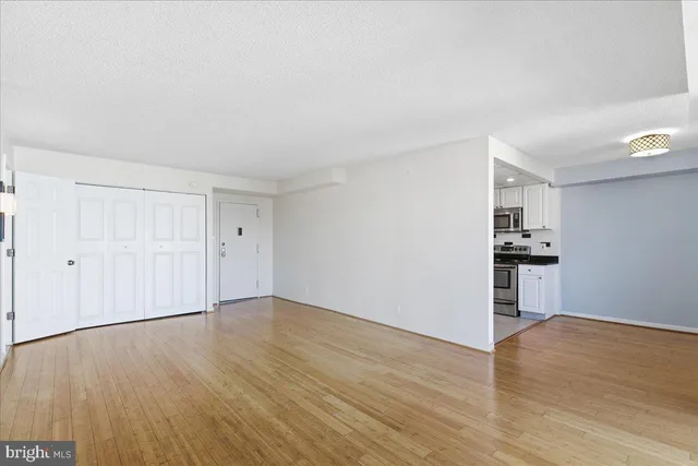 a view of empty room with wooden floor and window