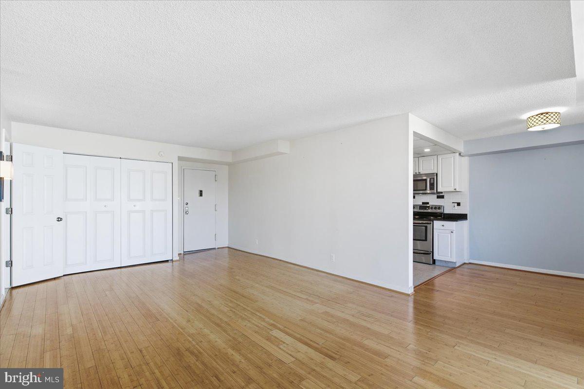 1401 North Rhodes Street, Unit 503 Arlington, VA 22209 - Photo 3 of 17 a view of empty room with wooden floor and window