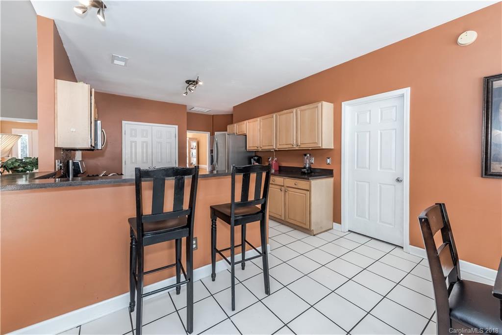 701 Monticello Drive Fort Mill, SC 29708 - Photo 3 of 21 a kitchen with stainless steel appliances kitchen island granite countertop a refrigerator a stove a dining table and chairs with wooden floor