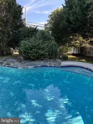 a view of yard with swimming pool and green space