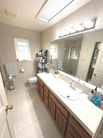 a living room with couches and a dining table with wooden floor