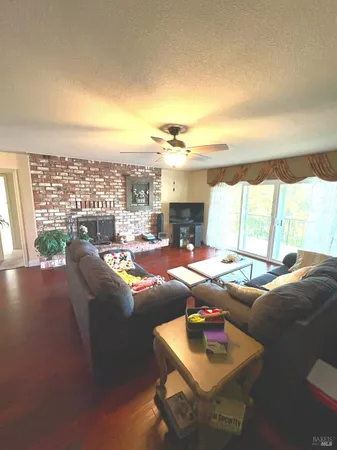 a living room with furniture and a table with wooden floor