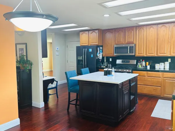 a kitchen with kitchen island granite countertop a sink cabinets and wooden floor