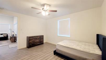 1709 Sycamore Street, Unit 1 Commerce, TX 75428 - Photo 14 of 17 a bedroom with a bed and wooden floor