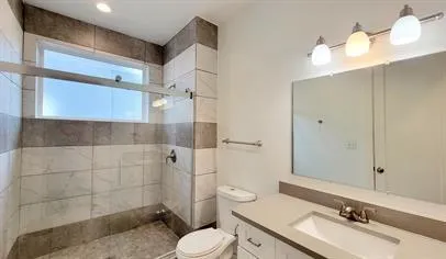 a bathroom with a sink a toilet and shower
