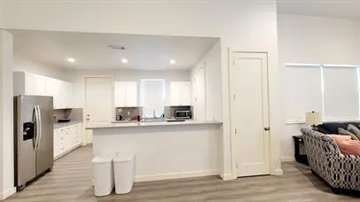 a kitchen with stainless steel appliances kitchen island granite countertop a refrigerator and a stove top oven