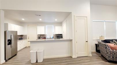 1709 Sycamore Street, Unit 1 Commerce, TX 75428 - Photo 7 of 17 a kitchen with stainless steel appliances kitchen island granite countertop a refrigerator and a stove top oven