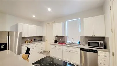 a kitchen with stainless steel appliances a stove a sink a refrigerator and cabinets