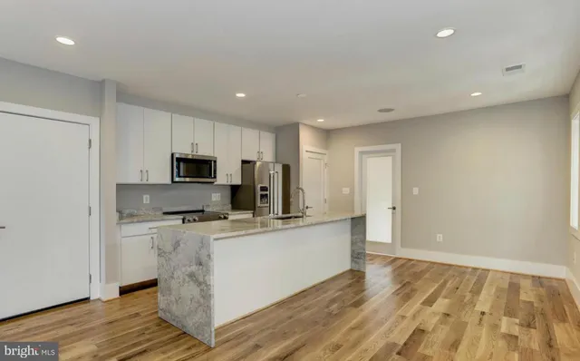 a kitchen with stainless steel appliances a microwave a stove a sink and a refrigerator