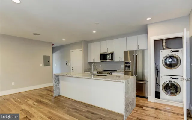 a kitchen with stainless steel appliances a stove a sink a refrigerator and cabinets