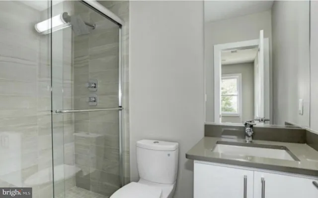 a bathroom with a granite countertop sink toilet and shower