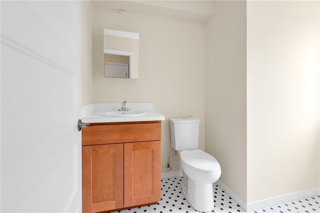 15 Stanton Road Brooklyn, NY 11235 - Photo 13 of 29 a bathroom with a toilet a sink and mirror