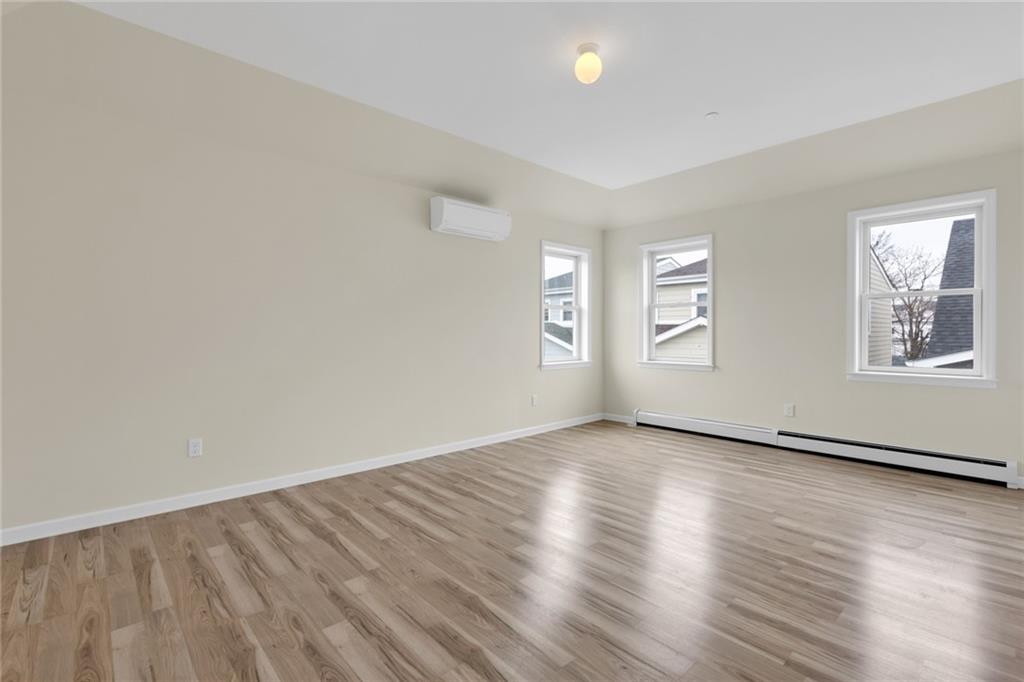 15 Stanton Road Brooklyn, NY 11235 - Photo 4 of 29 an empty room with wooden floor and windows