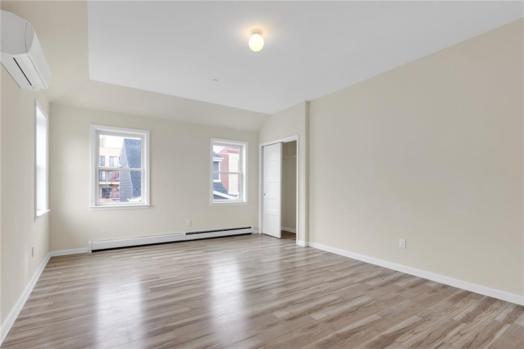 15 Stanton Road Brooklyn, NY 11235 - Photo 5 of 29 an empty room with wooden floor and windows