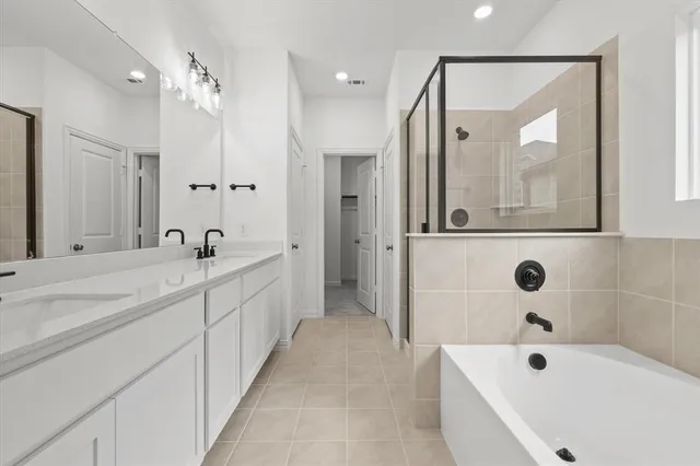a spacious bathroom with a tub a double vanity sink and mirror
