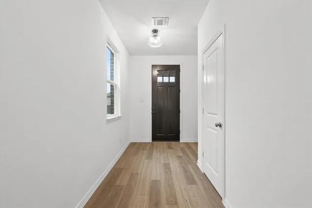 a view of a room with wooden floor and a bathroom
