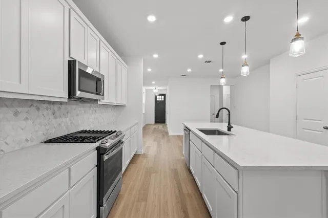 a kitchen with stainless steel appliances a sink stove and cabinets