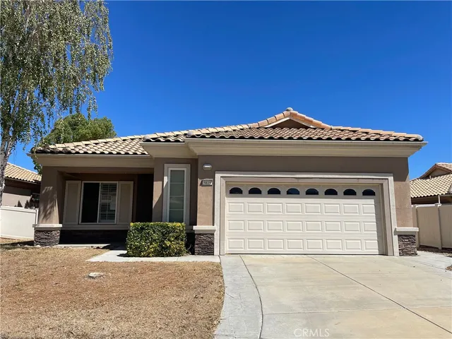 a front view of a house with a garage and a table