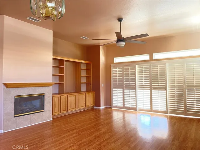 a view of empty room with wooden floor and fireplace