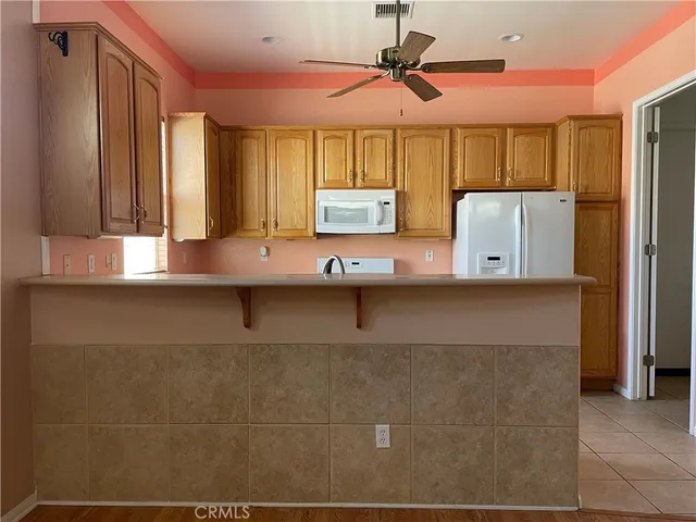a view of kitchen with stainless steel appliances granite countertop a sink a stove and a refrigerator