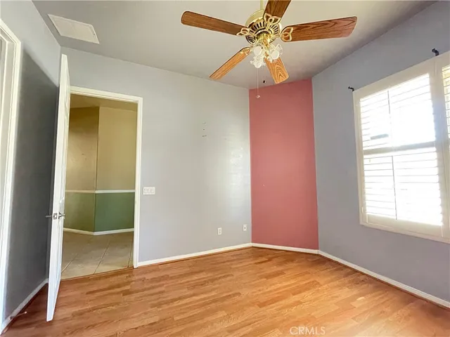 an empty room with fan and windows