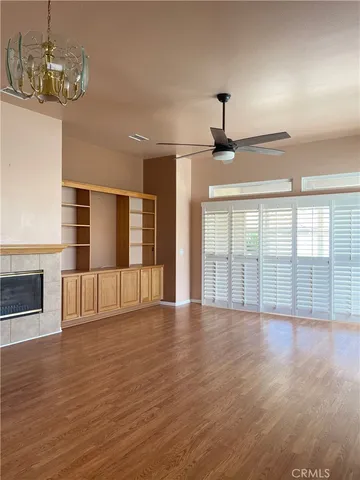 a view of an empty room with wooden floor and windows