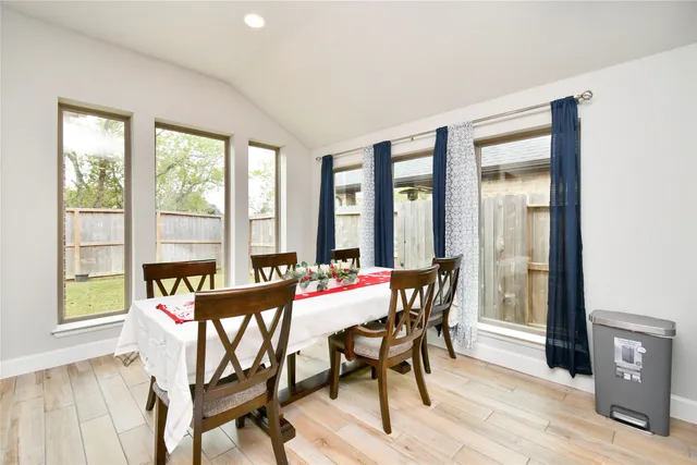 a view of a dining room with furniture large windows and wooden floor