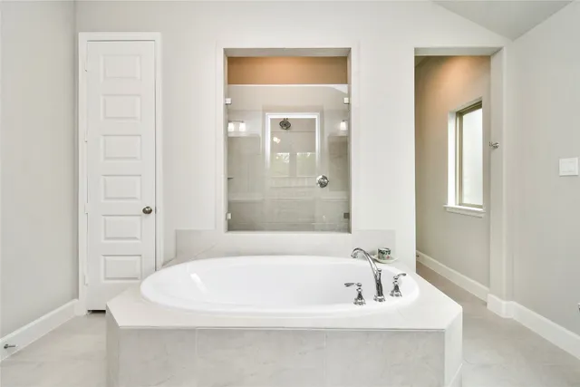 a white bath tub sitting in a bathroom near mirror