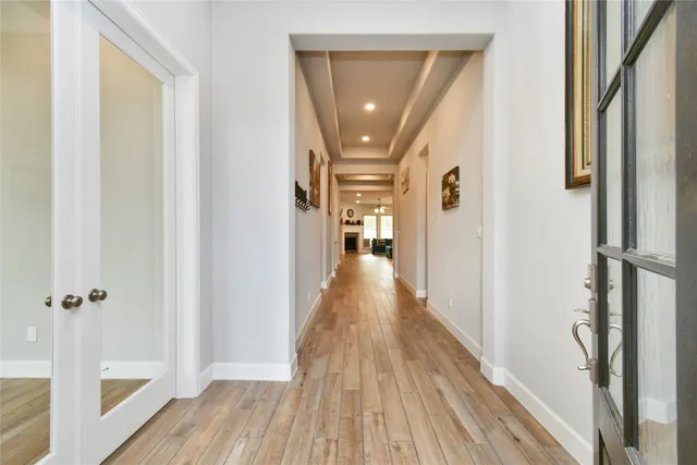 a view of a hallway with wooden floor and staircase