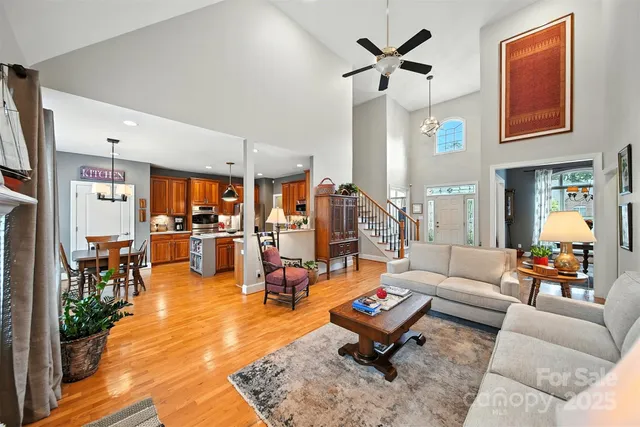 a living room with furniture kitchen view and a large window