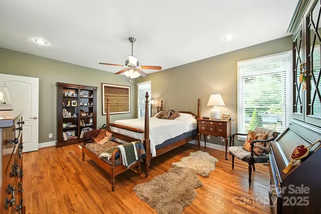 a spacious bedroom with a bed a table and a large window