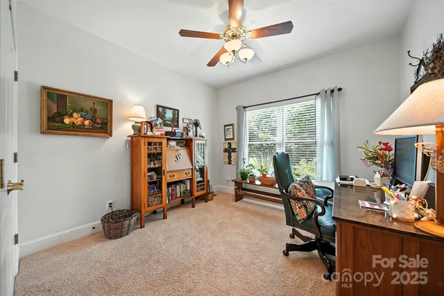 a view of a workspace with furniture and a window