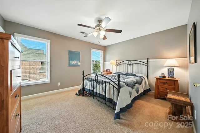 a spacious bedroom with a bed and a chandelier