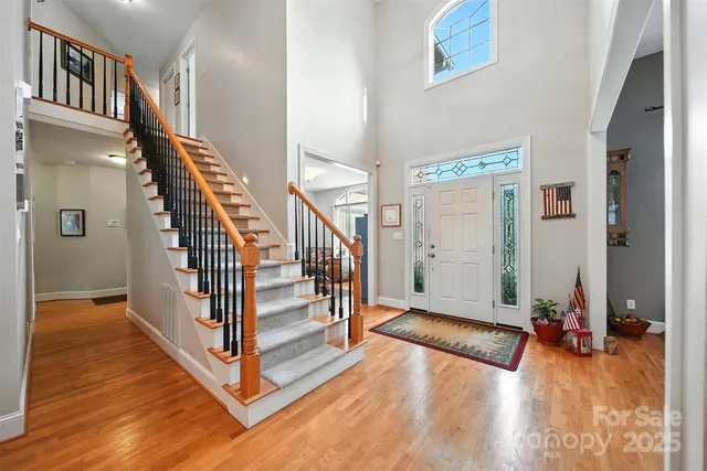 a view of a hallway with wooden floor and staircase