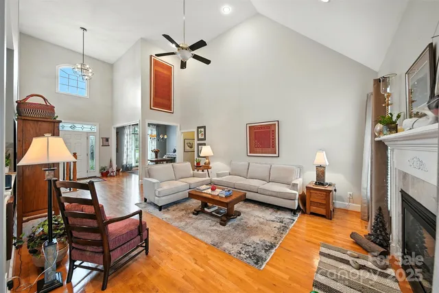 a living room with furniture a fireplace and a chandelier
