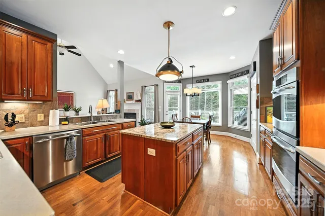a kitchen with kitchen island granite countertop a stove and a sink